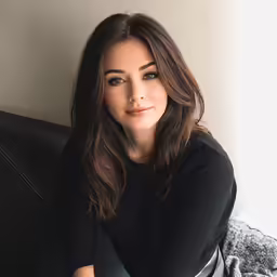 a woman sitting on a couch posing for a photo