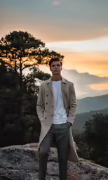 a man in business suit standing on top of a mountain