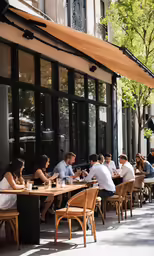 a crowd of people sitting outside a restaurant eating and talking