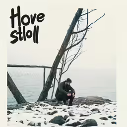 a man is sitting on a rock in the snow