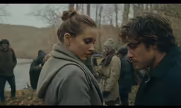 young couple in winter clothing staring at each other