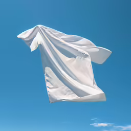 white fabric on top of a white wall in a blue sky