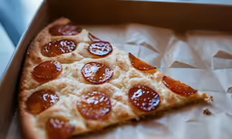 a pizza in a box with cheese and pepperoni