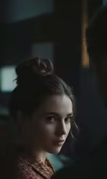 a woman looking at another man while holding his head back