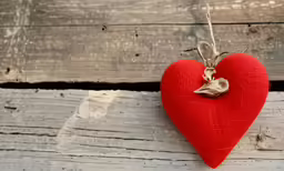 the small red heart is hanging from the wall