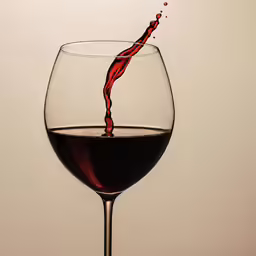 a wine glass is half full and has a wine trail going in the middle of the glass
