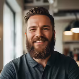 the man has a beard and blue shirt