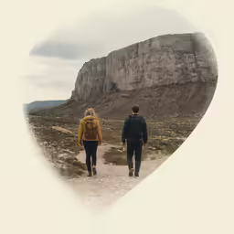 a couple walk hand in hand on a rocky path
