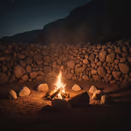 a campfire lit up by rocks with no one around it