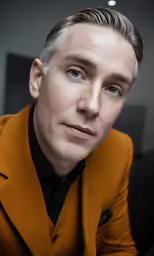 a man in a brown suit is posing
