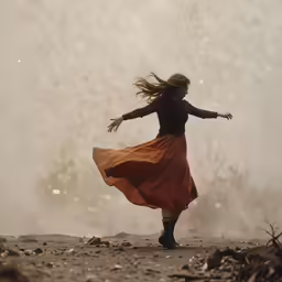 the woman in a long dress is dancing