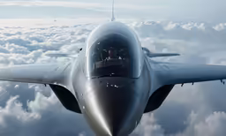 a silver plane flying above the clouds in daytime