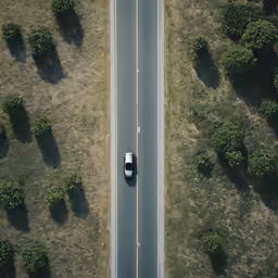 an aerial view of a road with a car on it