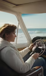 a woman sitting in a car looking out the window while driving