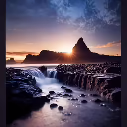 the sun is going down over a body of water and some rocks