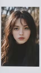 a woman with long brown hair and blue eyes is wearing black