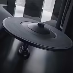 a close up of the top of a round table with a metal object on top