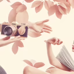 two girls reaching out toward one another to touch an object