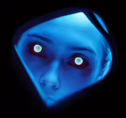 a woman with red eyes looking up in the dark