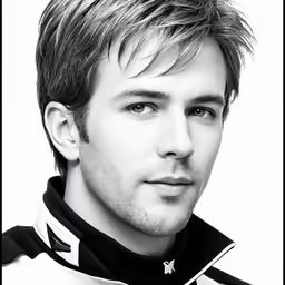 a man with short hair and a black and white jacket