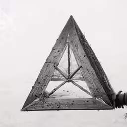 a triangular object hanging from a wooden pole