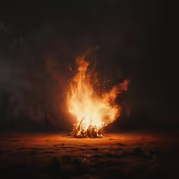 a bonfire is lit and blazing into the night sky
