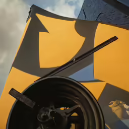 a black stick sitting on top of a yellow sign