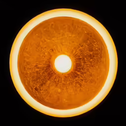 an orange and black circular object in the dark