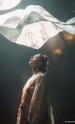 a woman looking up with her head turned toward a hanging object