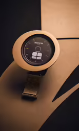 a modern style digital watch on a gold colored wristband