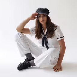 an image of a female model in white pants and a shirt