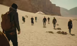 a group of people standing on top of a sandy beach