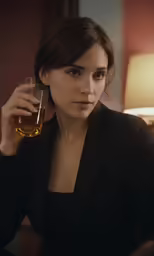 the young woman in a black suit holds up a glass