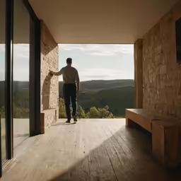 the man stands outside his home while the sun shines