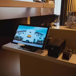a small computer on a shelf with a picture on the screen