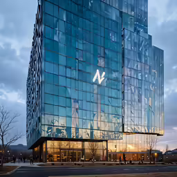 people walking in front of a building with a glass facade
