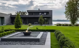 a large black home surrounded by lush green grass