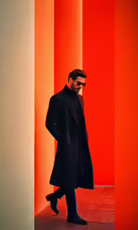 a man is standing by columns wearing sunglasses