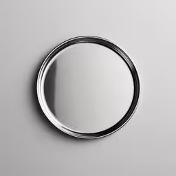 circular bathroom mirror on the wall,a silver mirror with no shadow on it