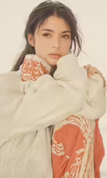 a woman wrapped in a blanket, with a concerned look