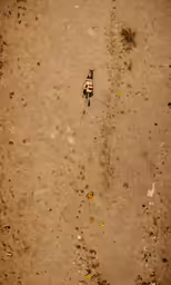 an aerial shot of a person sitting on the sand