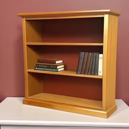 an open book shelf on top of a table,a book shelf has three books and three different stacks,a wooden shelf with three books on top of it,a yellow book shelf with two stacks of books on it,a tall bookshelf next to some empty books on the table