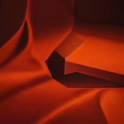 two boxes sitting on top of an orange blanket