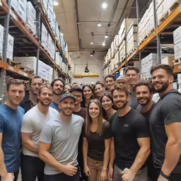 there are a group of people standing together in a warehouse