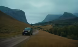 a truck is driving down the dirt road