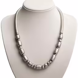 silver beads on a white necklace on a mannequin