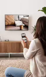 a woman sitting on a brown rug while looking at the television screen