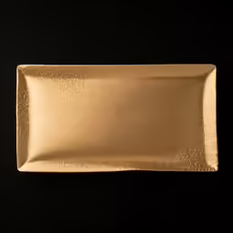 gold foiled plate is placed on a black surface