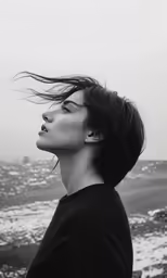 a young girl wearing earplugs is looking out on the ocean