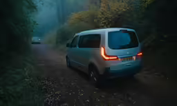 a car on a road going down some trees